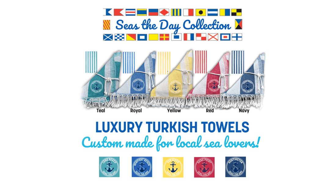 An assortment of colorful Turkish towels by Shaka Love with nautical designs, including anchors and flags, Seas the Day Collection is a great addition for every sea lover