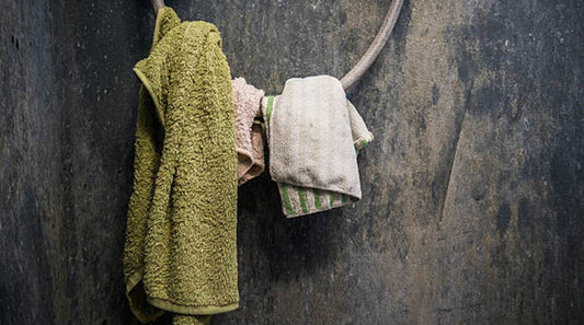 A close-up of several dirty towels hanging from a metal hook