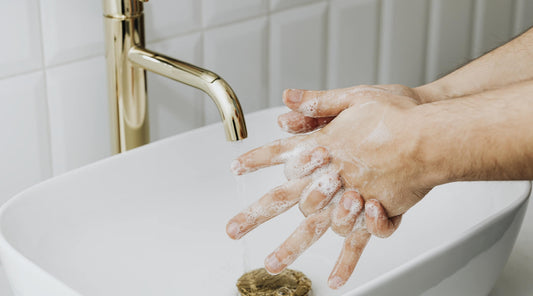 A man washing his hands and reaching for a hanging Turkish hand towel